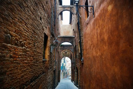 Street view with old buildings and archway in Siena, Italy.の写真素材