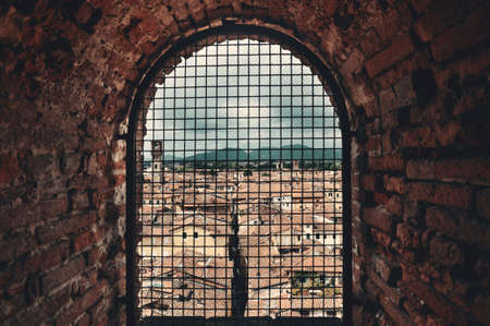 Medieval Town Lucca viewed through vintage window with historic buildings in Italy.の写真素材