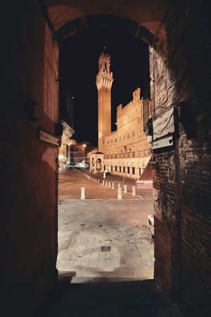 City Hall Bell Tower closeup at night viewed from archway in Siena Italy.の写真素材