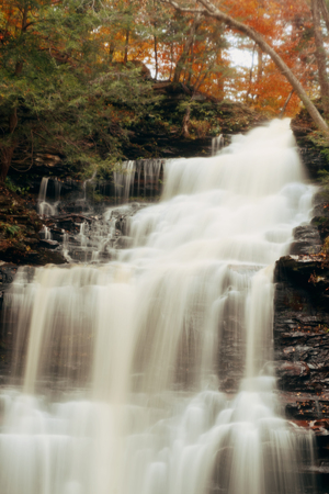 Autumn waterfalls in park with colorful foliage.の写真素材