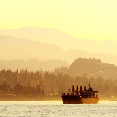 Abstract background of mountain range and city buildings and a cargo ship in Vancouver.の写真素材