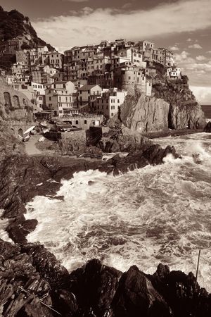 Manarola overlook Mediterranean Sea with buildings over cliff in Cinque Terre, Italy in black and whiteの写真素材
