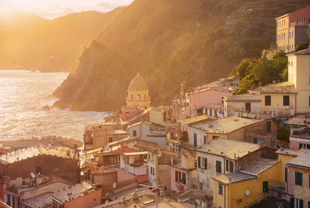 Colorful sunset in Vernazza with buildings on rocks over sea in Cinque Terre, Italy.の写真素材