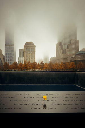 NEW YORK CITY - NOV 12: September 11 memorial in a foggy day on November 12, 2014 in Manhattan, New York City. With population of 8.4M, it is the most populous city in the United States.のeditorial素材
