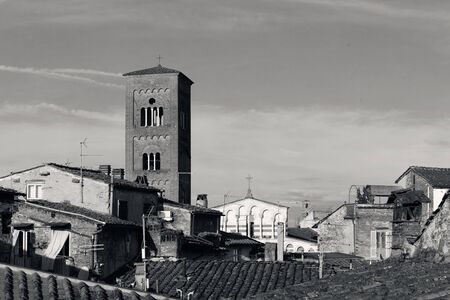 Tower of Chiesa San Pietro with roofs of historic buildings in Lucca, Italy.の写真素材