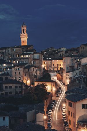 Medieval town skyline view with Siena Bell Tower and historic buildings in Italy at nightの写真素材