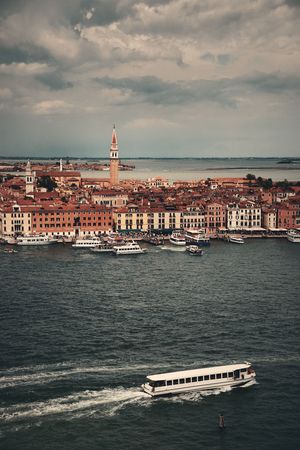 St Marks church clock tower and city skyline with boat viewed from San Giorgio Maggiore island in Venice, Italy.の写真素材
