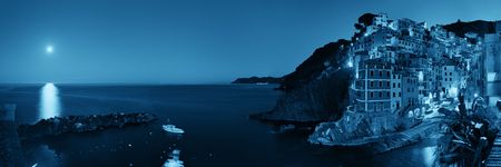Riomaggiore waterfront view with buildings and moonset in Cinque Terre at night panorama, Italy.の写真素材