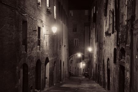Street view with old buildings at night in Siena, Italy.の写真素材