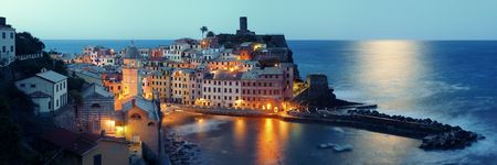 Vernazza at night with buildings on rocks over sea in Cinque Terre, Italy.の写真素材