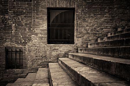 Italy Siena old building closeup with stairs and window on brick wallの写真素材