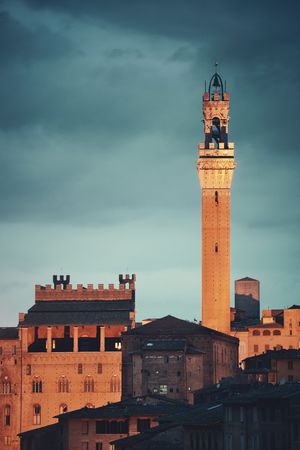 Medieval town Siena skyline view with Bell Tower and historic buildings in Italy at night