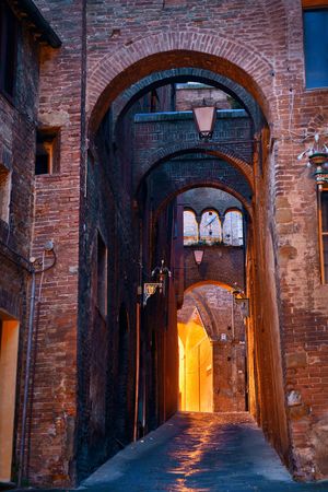 Street view with old buildings and archway in Siena, Italy.の写真素材