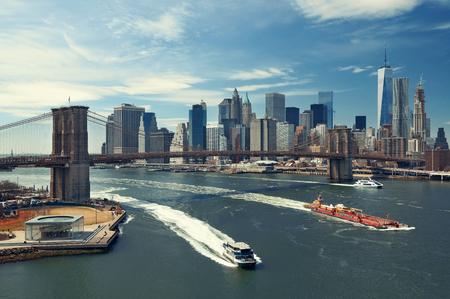 Brooklyn Bridge and downtown Manhattan skyline with boat in New York Cityの写真素材