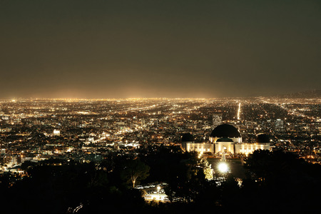 Los Angeles at night with urban buildings and Griffith Observatoryの写真素材