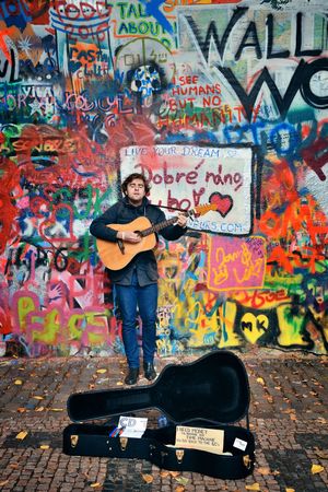 PRAGUE â€“ OCT 8: Street artist in front of graffiti on October 8, 2016 in Prague, Czech...