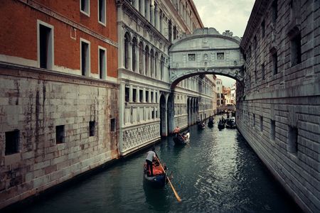 Gondola in canal with Bridge of Signs in Venice, Italy.の写真素材