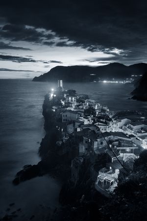 Vernazza at night with buildings on rocks over sea in Cinque Terre, Italy. Black and white.の写真素材