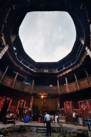 FUJIAN, CHINA â MARCH 2, 2018: Man clean the floor in Tulou. Tulou is the unique traditional rural dwelling of Hakka.のeditorial素材