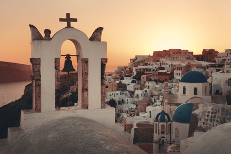 Santorini skyline sunset with church bell and buildings in Greece.の写真素材