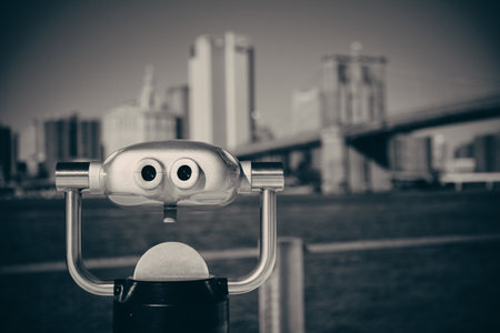 Binocular at waterfront with Brooklyn Bridge and skyscrapers.の写真素材