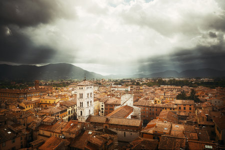 Lucca town skyline rooftop view with Bell Tower of Basilica di San Michele and sun ray in Italy.の写真素材