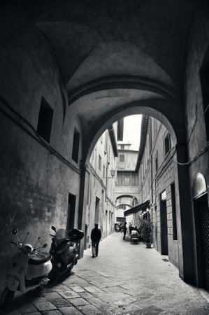 Street view with old buildings and archway in Siena, Italy.の写真素材