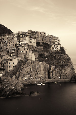 Manarola overlook Mediterranean Sea with buildings over cliff in Cinque Terre, Italy. Black and white.の写真素材