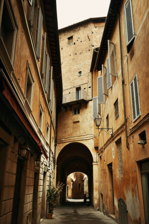 Street view with old buildings and archway in Siena, Italy.の写真素材