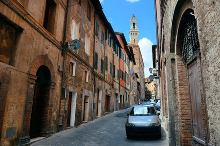 Street view with old buildings and bell tower in Siena, Italy.の写真素材