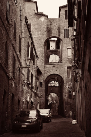 Street view with old buildings and archway in Siena, Italy.の写真素材