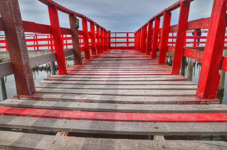Long  Wooden Red Bridge at beach sea Samut Sakhon Thailandの写真素材