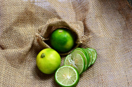 Fresh Citrus Fruits Organic Key Limes and lime slice on Burlap fabricの写真素材