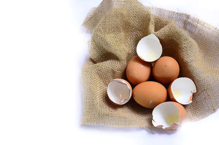 eggs and eggshell on sackchoth and white backgroundの写真素材