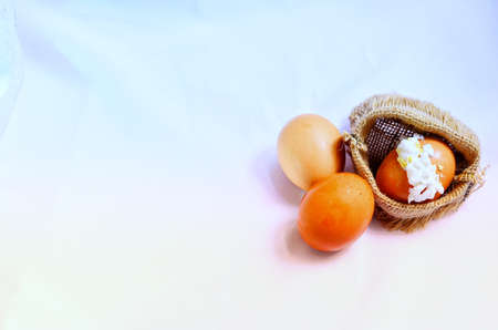 Three boiled eggs, one broken egg and albumin flowed from the outer shell on a sack cloth.の写真素材