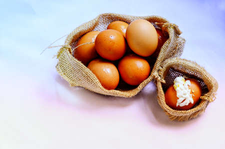 A pile of boiled eggs in a large sack bag and one broken egg in a small bag, vintage styleの写真素材