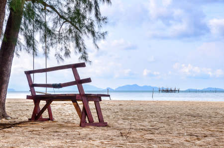 wooden chair on the sand beach at koh mak, thailandの写真素材