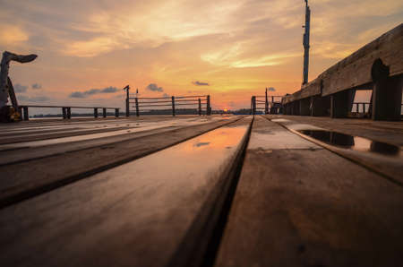 A wooden bridge that stretches to the sunrise like a path to a dreamの写真素材