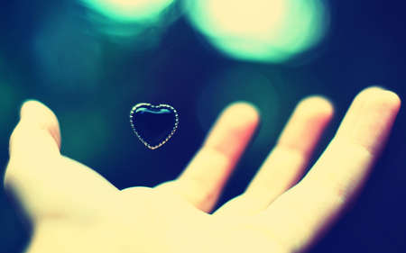 The little  heart rests above the palm of a man's hand.The idea of  love!