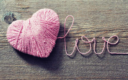 Two pink clews in shape of heart, wooden back ground. valentine day, happy love.の写真素材