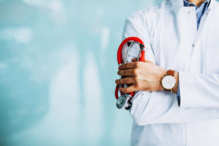 Young handsome physician in a medical robe with stethoscope