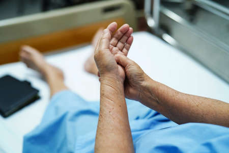 Asian senior woman patient pain her hand in hospital.