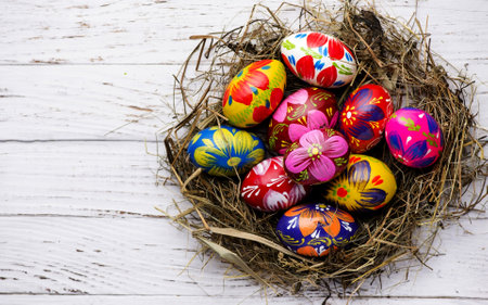 Colorful Painted Easter eggs in a nest. Wooden Background.