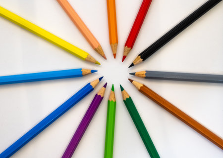 Colored pencils arranged in a circle on a white backgroundの写真素材