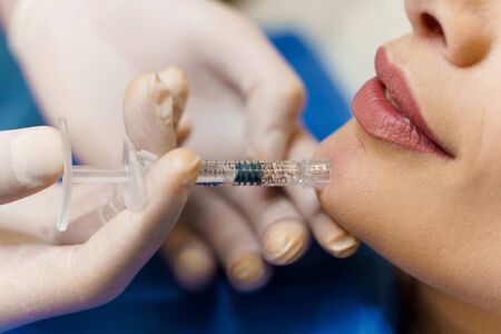 Closeup filler injection of hyaluronic acid. Contour plastic for correcting the volume and shape of the nose, chin, cheekbones, temples. Cosmetic rejuvenating facial treatment in medical clinicの写真素材