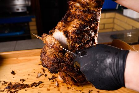 Fried pork cut with a knife. Big peace of pork meat. Cutting meat. Chef cut pork with knife. Advert for meat menu for restaurantの写真素材