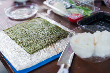 Cocking sushi rolls recipe with nori, rice, salmon, cucumber, and cheese. Tasty japanese food....