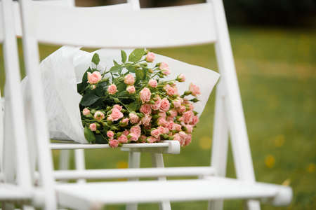 Wedding decoration of marriage ceremony in autumn. White chairs and wedding arch for couple in the forestの写真素材