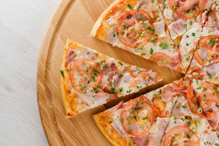 Pizza top view cutted on 8 pieces and one pushed forward. Advert for pizzeria caffee and restaurant. Food delivery at quarantine covid-19 concept.の写真素材