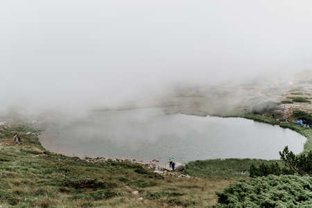 Mountain lake and in foggy day. Fog in Karpathian mountains. Tourism in Ukraine. Freedom and unity...